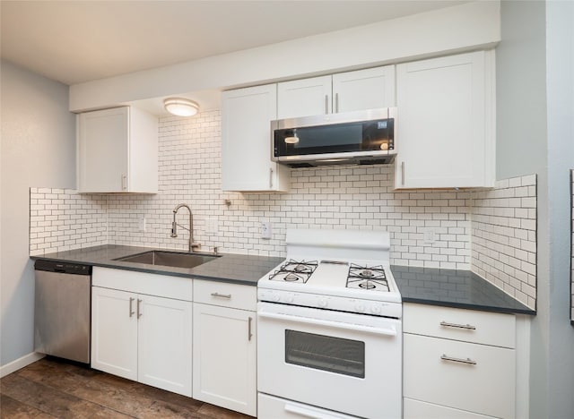 410 Blueberry Hl, Austin, TX 78745 - kitchen with appliances with stainless steel finishes, dark countertops, backsplash, and white cabinetry