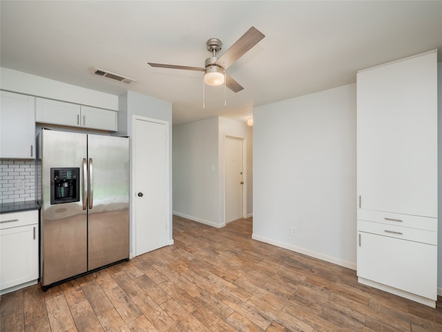 410 Blueberry Hl, Austin, TX 78745 - kitchen with stainless steel fridge, a ceiling fan, light wood finished floors, backsplash, and white cabinets