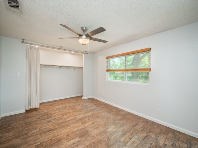 410 Blueberry Hl, Austin, TX 78745 - unfurnished bedroom featuring wood finished floors, a closet, a textured ceiling, and a ceiling fan
