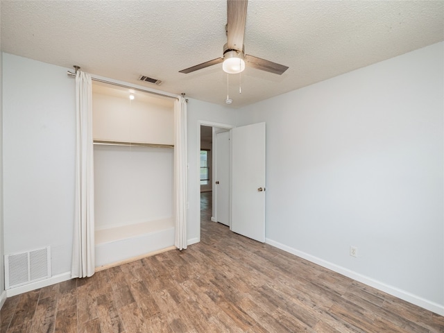 410 Blueberry Hl, Austin, TX 78745 - unfurnished bedroom featuring a closet, wood finished floors, a textured ceiling, and a ceiling fan