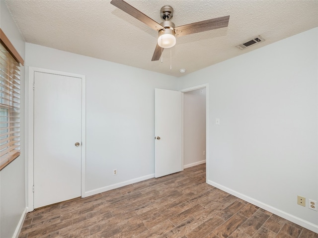 410 Blueberry Hl, Austin, TX 78745 - unfurnished bedroom with wood finished floors, a textured ceiling, a closet, and ceiling fan
