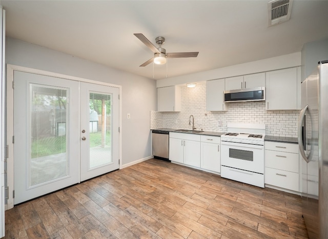 410 Blueberry Hl, Austin, TX 78745 - kitchen featuring stainless steel appliances, french doors, dark countertops, decorative backsplash, and white cabinets
