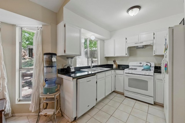 4802 Peach Grove Ct, Austin, TX 78744 - kitchen featuring white appliances, dark countertops, a sink, under cabinet range hood, and white cabinetry