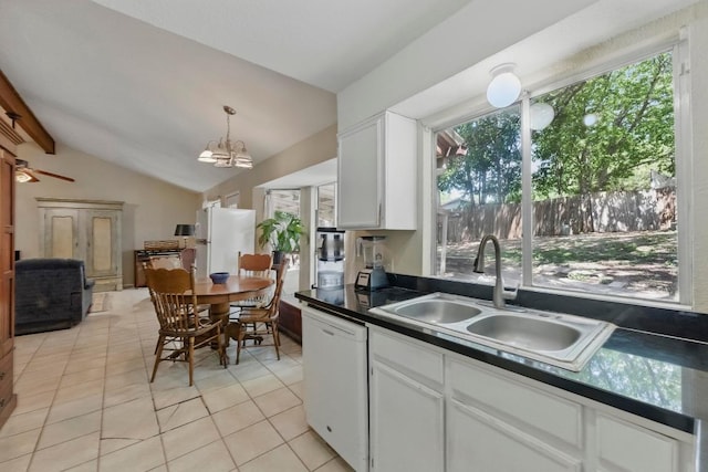 4802 Peach Grove Ct, Austin, TX 78744 - kitchen featuring white appliances, a sink, light tile patterned floors, dark countertops, and vaulted ceiling