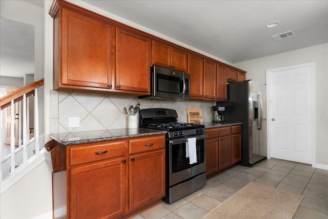 228 Wallops, Kyle, TX 78640 - kitchen featuring appliances with stainless steel finishes, tasteful backsplash, dark stone countertops, and brown cabinets