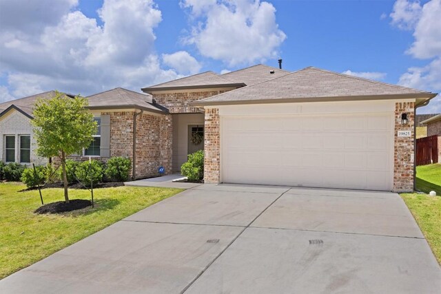 19825 Abigail Fillmore Rd, Manor, TX 78653 - view of front of house with concrete driveway, a garage, and a front yard