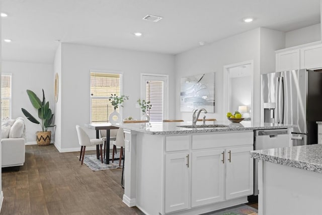 19825 Abigail Fillmore Rd, Manor, TX 78653 - kitchen with appliances with stainless steel finishes, dark wood-style flooring, white cabinetry, recessed lighting, and a center island with sink