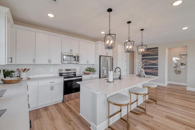17112 Vernal Rd, Manor, TX 78653 - kitchen featuring stainless steel appliances, a sink, tasteful backsplash, a chandelier, and light wood-style flooring