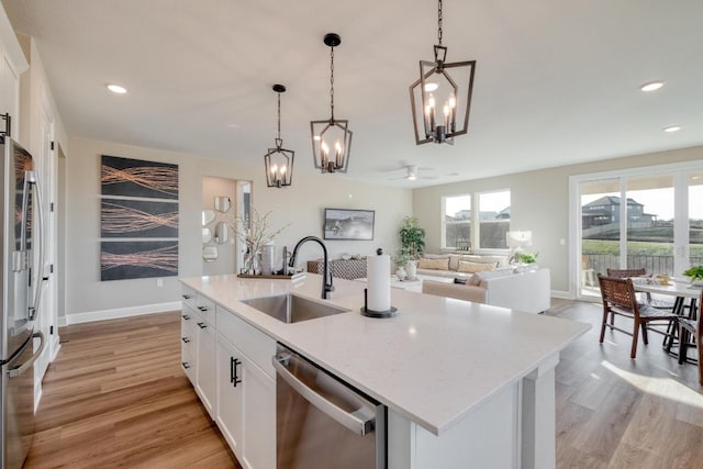 17112 Vernal Rd, Manor, TX 78653 - kitchen featuring stainless steel appliances, a sink, a chandelier, light wood finished floors, and a ceiling fan