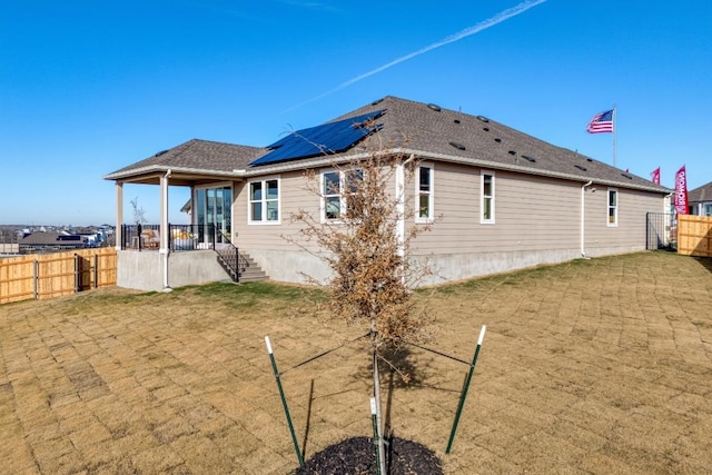 17112 Vernal Rd, Manor, TX 78653 - rear view of house featuring solar panels and a shingled roof