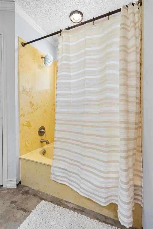 2201 Carolyn Dr, Taylor, TX 76574 - full bathroom with crown molding, shower / tub combo, unfinished concrete flooring, and a textured ceiling