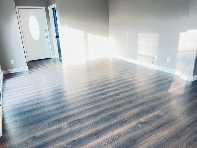 109 E Wheeler St S, Manor, TX 78653 - unfurnished living room with dark wood finished floors