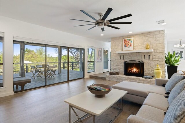 105 Palos Verdes Dr, Lakeway, TX 78734 - living room with wood finished floors, a stone fireplace, a ceiling fan, and recessed lighting