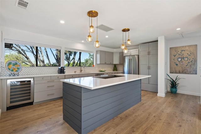 105 Palos Verdes Dr, Lakeway, TX 78734 - kitchen featuring wine cooler, gray cabinetry, high quality fridge, decorative backsplash, and black electric cooktop