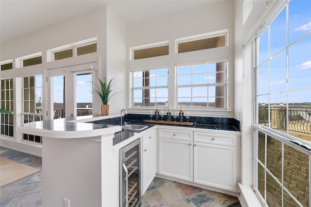 2918 Ranch Road 620 N Unit 299, Austin, TX 78734 - kitchen featuring wine cooler, white cabinetry, healthy amount of natural light, and a peninsula