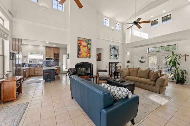 9300 N Madrone Trl, Austin, TX 78737 - living room featuring ceiling fan, a high ceiling, light tile patterned floors, a glass covered fireplace, and recessed lighting