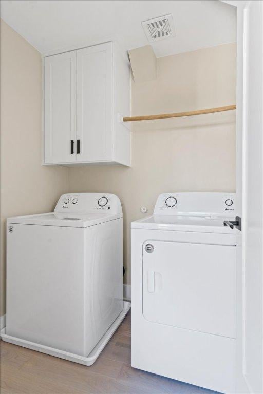 1405 Parkinson Dr, Austin, TX 78704 - laundry area featuring washer and clothes dryer, cabinet space, and light wood-type flooring