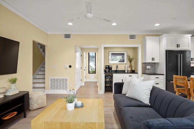 1405 Parkinson Dr, Austin, TX 78704 - living area with recessed lighting, baseboards, stairway, ornamental molding, and light wood-style floors
