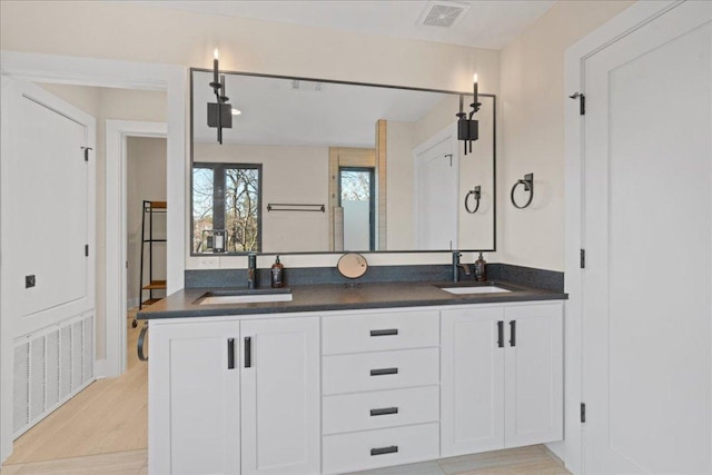 1405 Parkinson Dr, Austin, TX 78704 - full bathroom with double vanity and wood finished floors