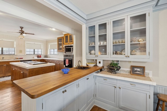 27846 Natural Bridge Caverns Rd, San Antonio, TX 78266 - kitchen with oven, a sink, crown molding, stainless steel microwave, and white gas cooktop