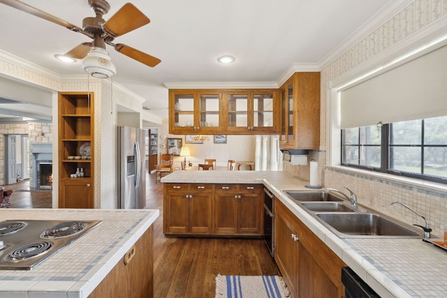 27846 Natural Bridge Caverns Rd, San Antonio, TX 78266 - kitchen with stainless steel appliances, a sink, brown cabinets, dark wood finished floors, and a peninsula