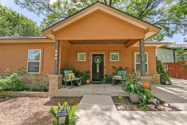 810 Monterrey St, Lockhart, TX 78644 - doorway to property with stone siding, covered porch, and stucco siding