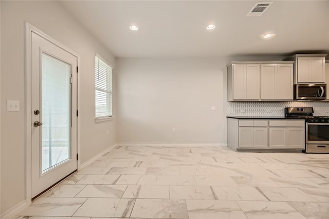 2009 Jacey Way, Austin, TX 78725 - kitchen featuring stainless steel appliances, light marble finish floors, recessed lighting, tasteful backsplash, and baseboards