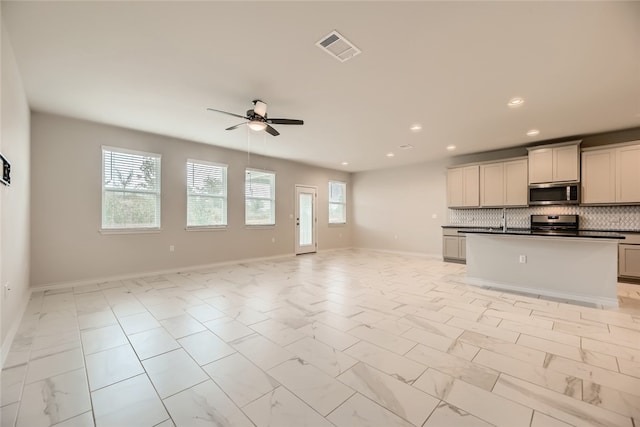 2009 Jacey Way, Austin, TX 78725 - kitchen featuring stainless steel microwave, open floor plan, stove, a ceiling fan, and recessed lighting