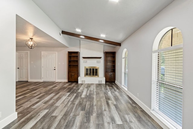 220 E Belton Ave, Rockdale, TX 76567 - unfurnished living room with wood finished floors, baseboards, and a fireplace