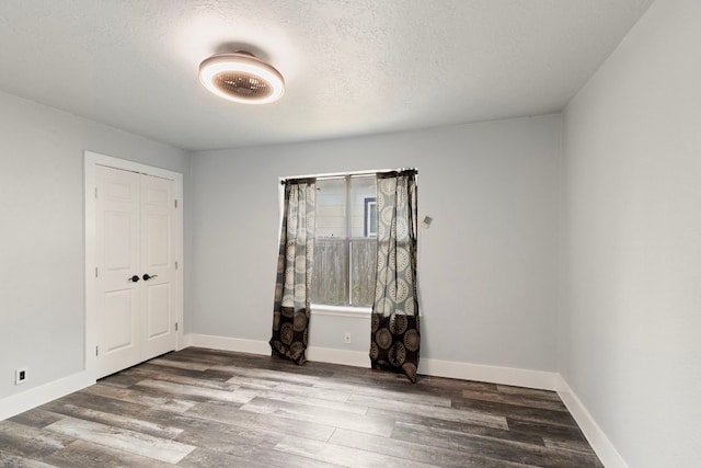 220 E Belton Ave, Rockdale, TX 76567 - empty room featuring wood finished floors, baseboards, and a textured ceiling