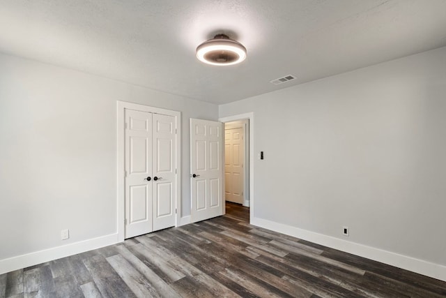 220 E Belton Ave, Rockdale, TX 76567 - unfurnished bedroom featuring baseboards, dark wood finished floors, and a closet
