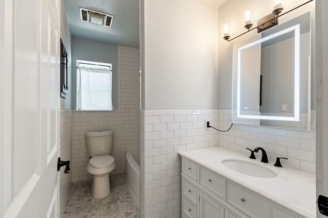 220 E Belton Ave, Rockdale, TX 76567 - bathroom featuring toilet, a bath, vanity, and tile walls