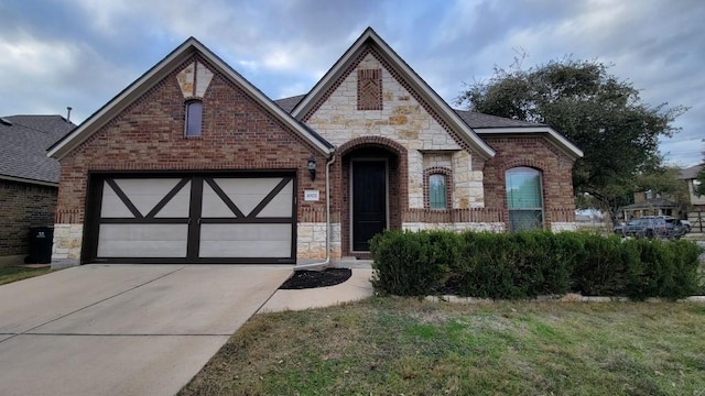 1002 Boxwood Loop, Georgetown, TX 78628 - view of front of house featuring stone siding, driveway, brick siding, and a garage