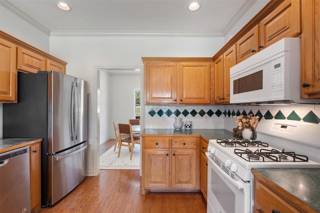 14717 Crosscreek Dr, Austin, TX 78737 - kitchen featuring stainless steel appliances, dark countertops, backsplash, light wood-style floors, and crown molding