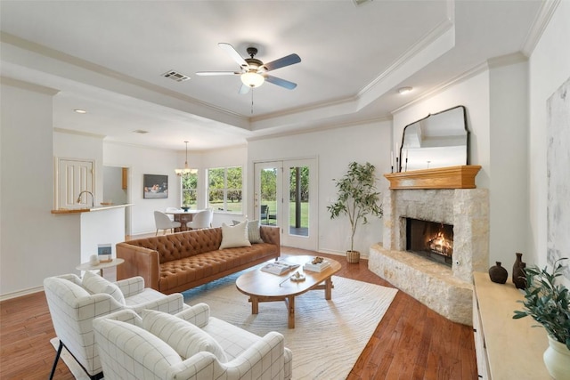14717 Crosscreek Dr, Austin, TX 78737 - living room with a tray ceiling, ornamental molding, a ceiling fan, a stone fireplace, and hardwood / wood-style flooring