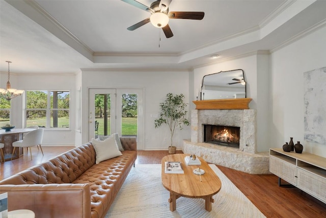 14717 Crosscreek Dr, Austin, TX 78737 - living room featuring a tray ceiling, ceiling fan, wood finished floors, a warm lit fireplace, and crown molding