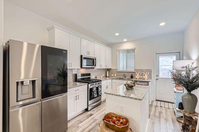 1521 W Kerr Pass, Leander, TX 78641 - kitchen with appliances with stainless steel finishes, white cabinetry, light wood-style flooring, decorative backsplash, and recessed lighting