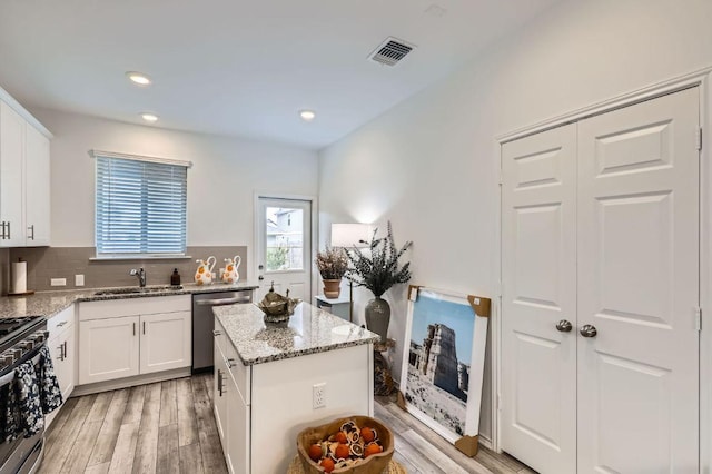 1521 W Kerr Pass, Leander, TX 78641 - kitchen featuring stainless steel appliances, light stone counters, light wood finished floors, decorative backsplash, and recessed lighting