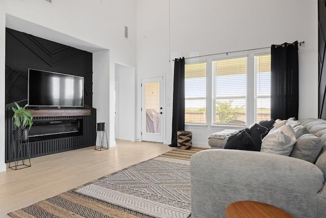400 Turnbuckle Bnd, Leander, TX 78641 - living room with a towering ceiling, wood finished floors, and a glass covered fireplace