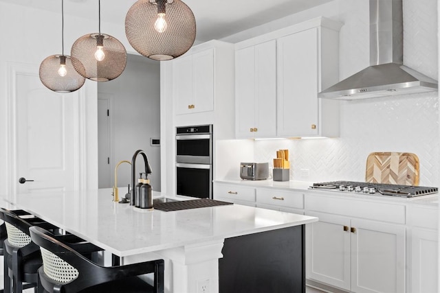 400 Turnbuckle Bnd, Leander, TX 78641 - kitchen featuring wall chimney exhaust hood, stainless steel appliances, tasteful backsplash, a breakfast bar, and white cabinets