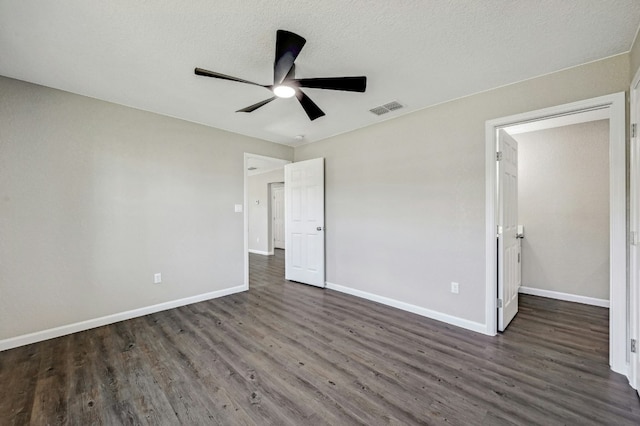 212 Walnut Ave, Luling, TX 78648 - unfurnished bedroom with dark wood-type flooring, ceiling fan, and a textured ceiling