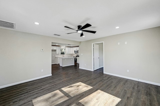212 Walnut Ave, Luling, TX 78648 - unfurnished living room featuring a ceiling fan, dark wood finished floors, and recessed lighting