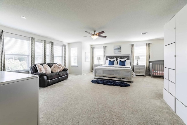 1224 Euless Ln, Leander, TX 78641 - bedroom featuring multiple windows, light carpet, ceiling fan, and a textured ceiling