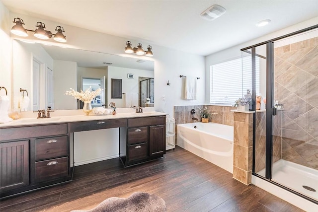 1224 Euless Ln, Leander, TX 78641 - full bath featuring a bath, double vanity, a stall shower, and wood finished floors