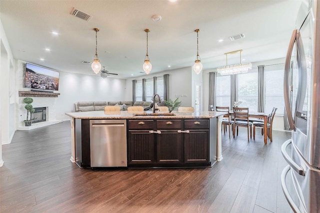 1224 Euless Ln, Leander, TX 78641 - kitchen featuring stainless steel appliances, dark brown cabinets, dark wood-style floors, open floor plan, and recessed lighting