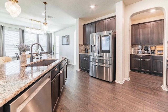 1224 Euless Ln, Leander, TX 78641 - kitchen with stainless steel appliances, backsplash, dark wood-style flooring, light stone counters, and dark brown cabinetry