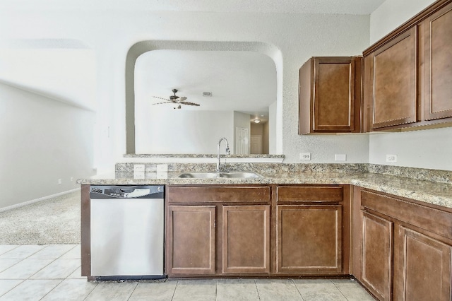 121 Talon Dr, Luling, TX 78648 - kitchen featuring stainless steel dishwasher, a sink, light stone countertops, light tile patterned floors, and a ceiling fan