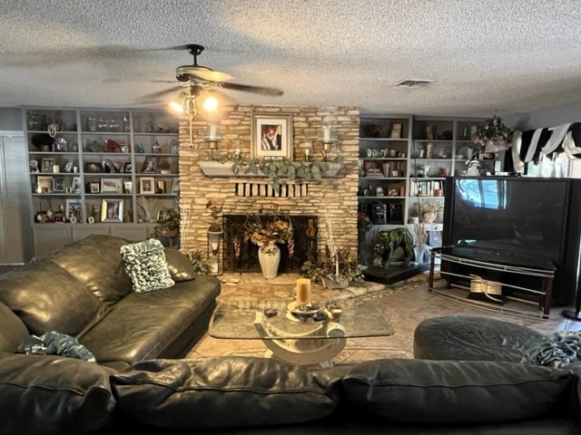 4605 Eck Ln, Austin, TX 78734 - living area with ceiling fan, a textured ceiling, a fireplace, and built in shelves