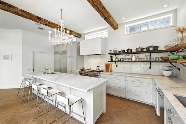 1700 S 6th St, Austin, TX 78704 - kitchen featuring stainless steel appliances, open shelves, beam ceiling, tasteful backsplash, and premium range hood