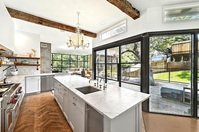 1700 S 6th St, Austin, TX 78704 - kitchen with a sink, beamed ceiling, appliances with stainless steel finishes, plenty of natural light, and a center island with sink